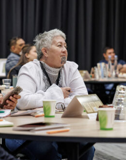 People in a conference room sitting down at different tables.