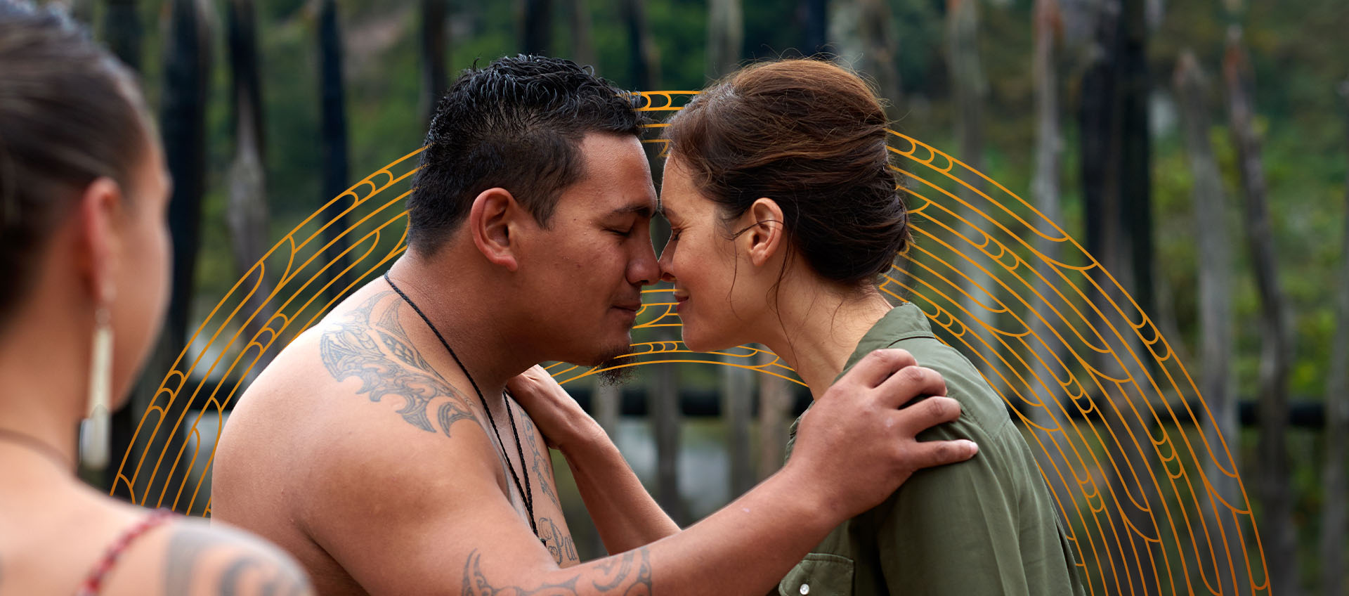 A Māori man and Pakeha woman hongi in greeting 