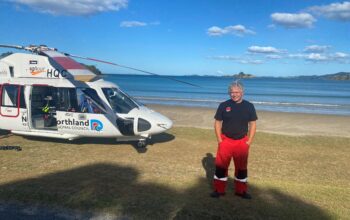 A person standing in front of a helicopter.