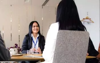 Three people sitting down at a table.