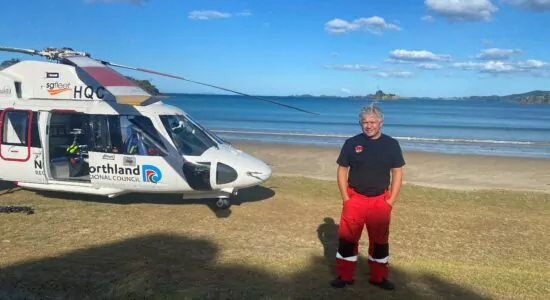 A person standing in front of a helicopter.